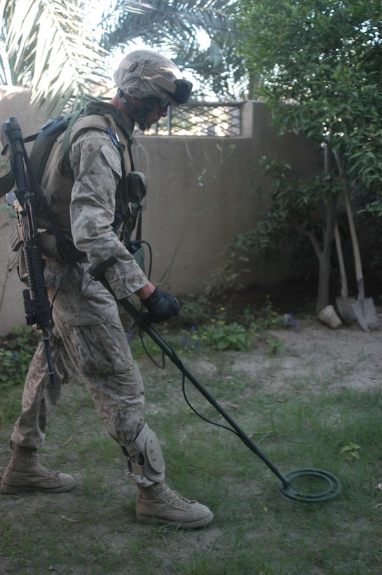 AR RAMADI, Iraq (May 7, 2005) -Lance Cpl. Robert O. Page, a combat engineer with 1st Combat Engineer Battalion, uses his metal detector ton search for weapons caches in the yard of a house here. The 20-year-old from Nashville, Tenn., and other blast masters with 1st CEB assisted Marines with 1st Battalion, 5th Marine Regiment, in conducting "Operation Weston." The infantry battalion's Company's A, C and W conducted the operation, which was a three-hour cordon and search mission of a neighborhood. The purpose of the mission was to eradicate the area of insurgents and inform the people living there of the consequences for harboring terrorists. The Marines hit three improvised explosive devises and found one 155 mm shell. One Marine received minor shrapnel wounds, and no insurgents were captured. Photo by Cpl. Tom Sloan