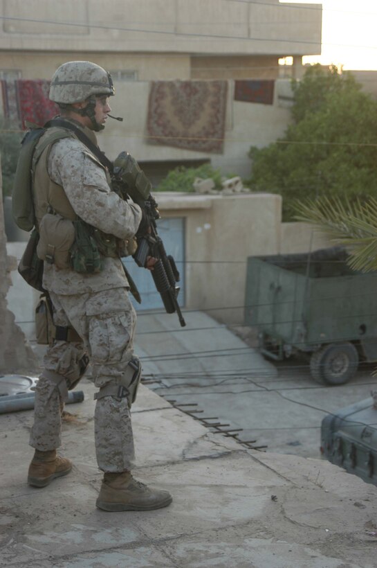 AR RAMADI, Iraq (May 7, 2005) - Corporal Josef A. Hensgens, a grenadier with 3rd Squad, 2nd Platoon, Company A, 1st Battalion, 5th Marine Regiment, posts security from the rooftop of a building here during an operation with his fellow leathernecks. The 21-year-old from Lafayette, La., and other warriors with the infantry battalion's Company's A, C and W conducted "Operation Weston," which was a three-hour cordon and search mission of a neighborhood. The purpose of the mission was to eradicate the area of insurgents and inform the people living there of the consequences for harboring terrorists. The Marines hit three improvised explosive devises and found one 155 mm shell. One Marine received minor shrapnel wounds, and no insurgents were captured. Photo by Cpl. Tom Sloan