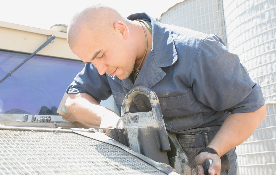 Hadithah Dam, Al Anbar, Iraq.-- Lance Cpl. Robert J. Gutfranski, a mechanic with H&S Company performs preventative maintenance on a HMWVV.  The 26-year-old from Rocky River, Ohio and other mechanics are available around the clock to fix vehicle problems.  The mechanics are capable of simple tune-ups to frame-off repair.  (Photo by LCpl. Marc Fencil. )