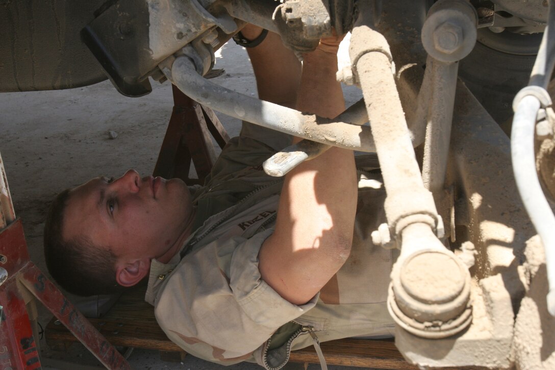 Hadithah Dam, Al Anbar, Iraq.-- Sgt. Paul J. Kozel,24,  inspects a broken suspension on a HMMWV damaged by a mine.  Kozel, a 2/14 mechanic is from Lagrange, Texas.  Vehicle operation in Iraq is especially hard on the vehicles' suspension systems.  Off-road use is responsible for more damage than the actual roads themselves however.  (Photo by LCpl. Marc Fencil.)