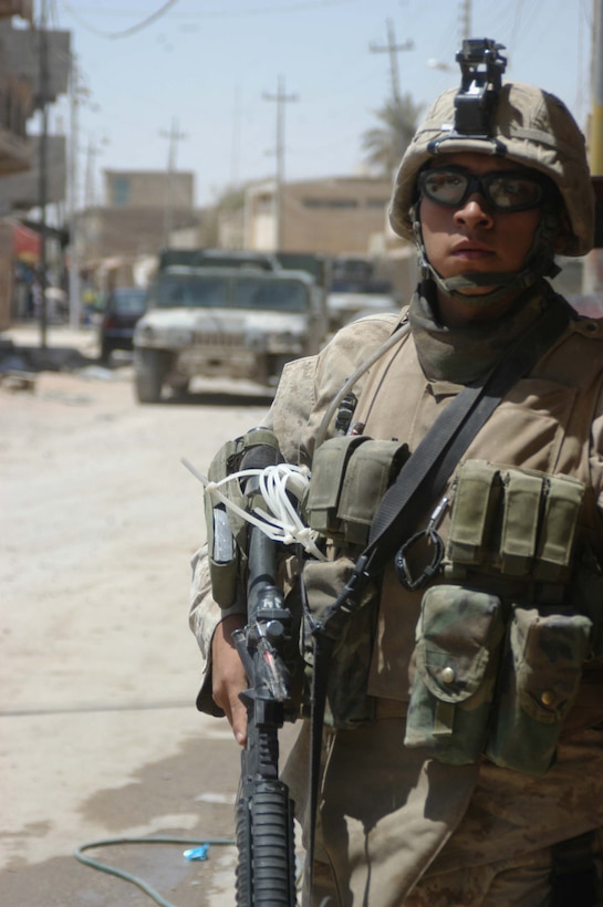 AR RAMADI, Iraq (June 7, 2005) - Lance Cpl. Victor M. Solorzano, a rifleman with 3rd Squad, 1st Platoon, Company A, 1st Battalion, 5th Marine Regiment, patrols down a street on foot during a mission in the marketplace here. The 21-year-old from Las Vegas and his fellow Company A Marines searched several buildings on a mile-long stretch of road that bisects the city's marketplace during "Operation Weatherford III." Two squads of Iraqi Security Forces assisted the Marines during the three-hour mission, which was aimed at finding sniper positions, weapons caches, improvised explosive device making material and suspicious individuals. Photo by: Cpl. Tom Sloan