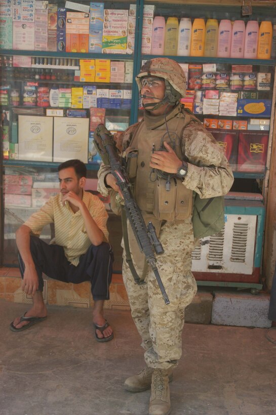 AR RAMADI, Iraq (June 7, 2005) - Staff Sgt. Daniel Santiago, the platoon sergeant for 1st Platoon, Company A, 1st Battalion, 5th Marine Regiment, talks to his Marines on his radio during a mission in the city here. Company A Marines searched several buildings on a mile-long stretch of road that bisects the city's marketplace during "Operation Weatherford III." Two squads of Iraqi Security Forces assisted the Marines during the three-hour mission, which was aimed at finding sniper positions, weapons caches, improvised explosive device making material and suspicious individuals. Photo by: Cpl. Tom Sloan