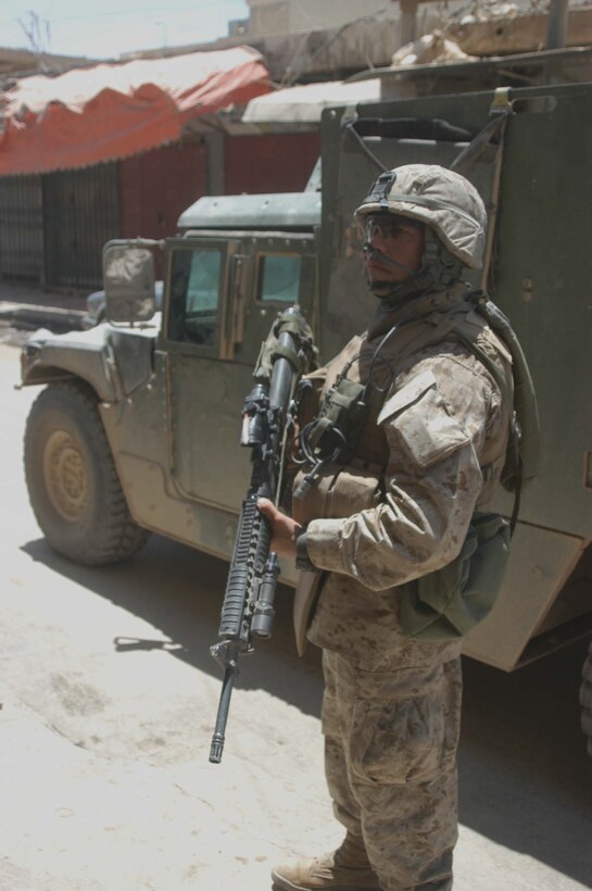AR RAMADI, Iraq (June 7, 2005) - Staff Sgt. Daniel Santiago, the platoon sergeant for 1st Platoon, Company A, 1st Battalion, 5th Marine Regiment, keeps a vigilant watch down a street during a mission in the city here. Company A Marines searched several buildings on a mile-long stretch of road that bisects the city's marketplace during "Operation Weatherford III." Two squads of Iraqi Security Forces assisted the Marines during the three-hour mission, which was aimed at finding sniper positions, weapons caches, improvised explosive device making material and suspicious individuals. Photo by: Cpl. Tom Sloan