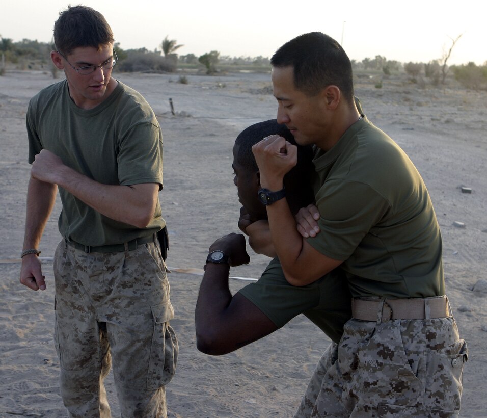 CAMP BAHARIA, Iraq - First Lieutenant Dana Sanford, 1st Battalion, 6th Marine Regiment's motor transport section's assistant officer-in-charge, demonstrates a proper choke hold technique during a martial arts training session here July 29.  The 24-year-old Sterling, Mass. native is a green belt instructor in the Marine Corps Martial Arts Program, and is currently teaching several Marines and sailors in his unit self-defense.