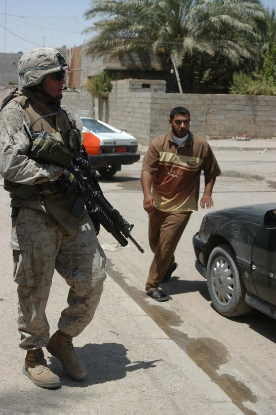 AR RAMADI, Iraq (July 31, 2005) - Corporal Grant R. Birtcher, a rifleman with the Combine Action Platoon, Company B, 1st Battalion, 5th Marine Regiment, patrols a street in the city here during a mission July 31. Birtcher, a 20-year-old half Navajo American Indian from Window Rock, Ariz., leads newly trained members of the ISF on missions in the city to hone their military skills. The 2002 Window Rock High School graduate conducts daily missions in the city with his ISF counterparts. Birtcher and between 12 and 24 ISF accompany Marines with 1st Battalion, 5th Marines. Photo by: Cpl. Tom Sloan