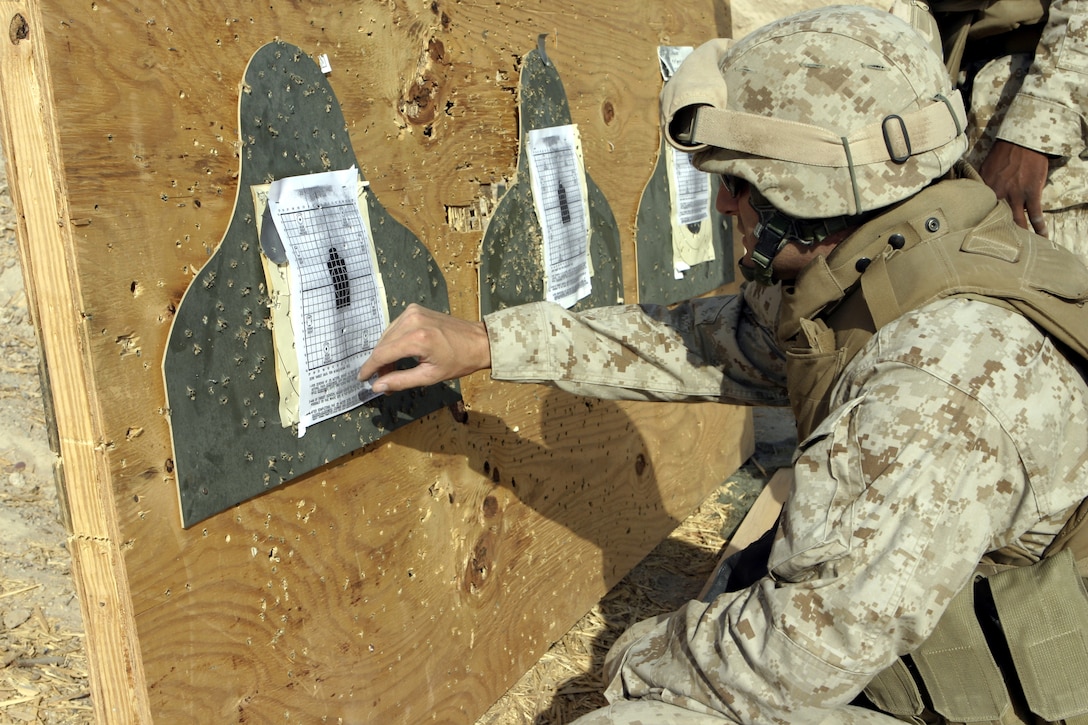 CAMP BAHARIA, Iraq - A corpsman with 1st Battalion, 6th Marine Regiment checks his target after having fired his M16A2 service rifle to acquire a battle sight zero here Aug. 7.  Several of the unit's 'docs' adjusted their rifles' sights before firing an M9 Beretta pistol qualification course to earn their service's pistol qualification ribbon.