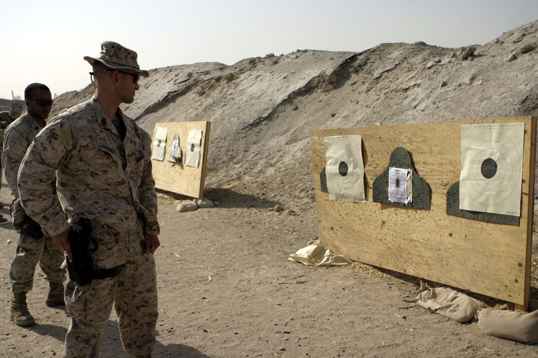 CAMP BAHARIA, Iraq - Navy Lt. Jared Vogler, 1st Battalion, 6th Marine Regiment's medical officer, prepares to un-holster his M9 Beretta and shoot a target here Aug. 7.  Several of the unit's corpsmen practiced how to un-holster their weapons and quickly shoot targets to earn their service's pistol qualification ribbon.