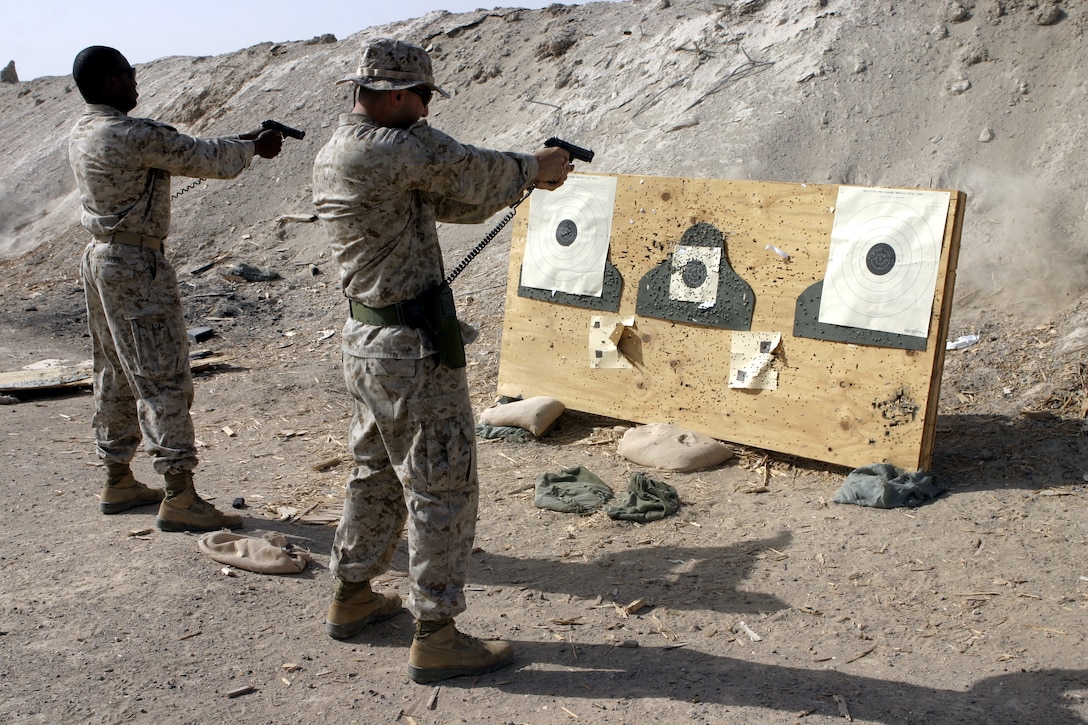 CAMP BAHARIA, Iraq - Corpsmen with 1st Battalion, 6th Marine Regiment fire their M9 Berettas during a training range here Aug. 7.  Several of the unit's 'docs' practiced how to un-holster their weapons and quickly shoot targets to earn their service's pistol qualification ribbon.