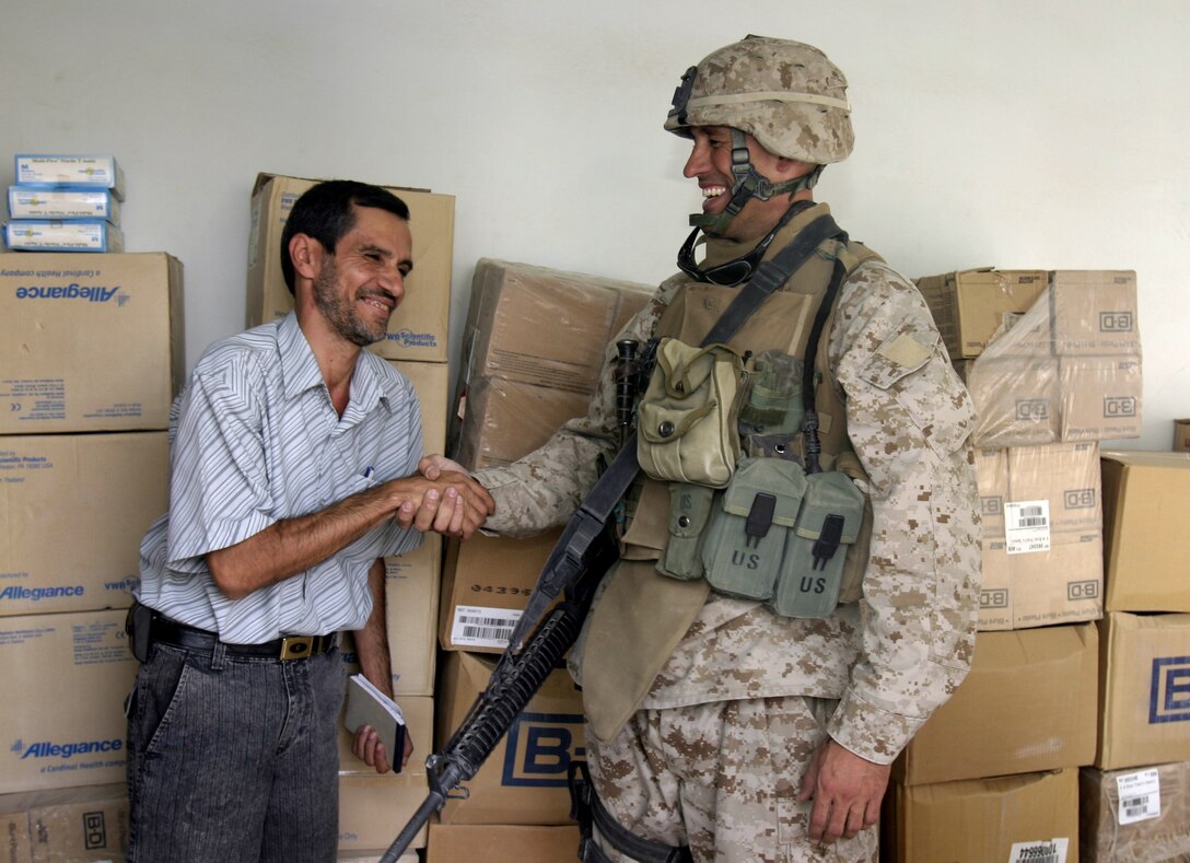 SAQLAWIYAH, Iraq - Major Chris E. Phelps, Team 3, Detachment 2, 5th Civil Affairs Group team leader and Shawnee, Kan. native, shakes hands with Dr. Ayad al-Hadithy, a doctor at the Saqlawiyah medical clinic, Sept. 7 after the CAG Marines dropped off boxes of supplies for the clinic.  The Marines distributed more than $4,000 worth of medical supplies that were donated by the Kansas-based nongovernmental organization Heart to Heart International to the clinic here.  Team 3 Marines have operated in and around this area since April to help restore the city's government, police force and infrastructure.