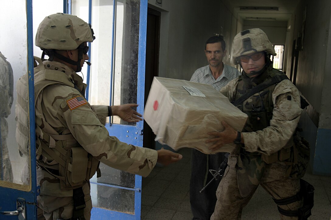 SAQLAWIYAH, Iraq - Sergeant Matt Dreher, a Marine with Team 3, Detachment 2, 5th Civil Affairs Group, receives a box of medical supplies to place inside Saqlawiyah's medical clinic Sept. 7.  The CAG Marines distributed more than $4,000 worth of medical supplies that were donated by the Kansas-based nongovernmental organization Heart to Heart International to the clinic here.  Team 3 Marines have operated in and around this area since April to help restore the city's government, police force and infrastructure.