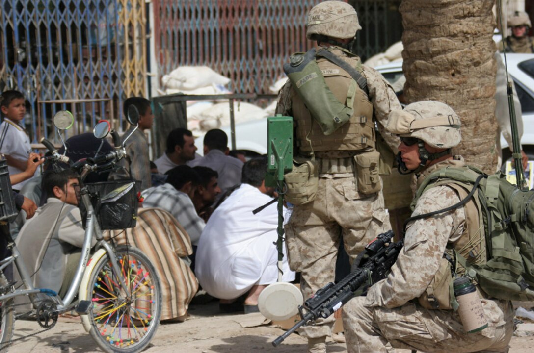 050907-M-2607O-003 KARMA, Iraq -- Marines from 2nd Battalion, 2nd Marine Regiment, watch a group of Iraqi locals and provide security during Operation Free Market, Sept. 7.  Approximately one-third of the battalion and numerous Iraqi soldiers were involved in this operation to try and retrieve information and IED materials from the market.