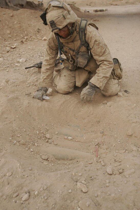 Husaybah, Iraq ( November 7, 2005)--Scouts and combat engineers with 2nd platoon, 1st LAR discover a massive IED during Operation Steel Curtain, placed in four different locations a few yards from each other and ranged from four to five artillery shell and a propane tank. (Official U. S. Marine Corps photo by Corporal Ken Melton)