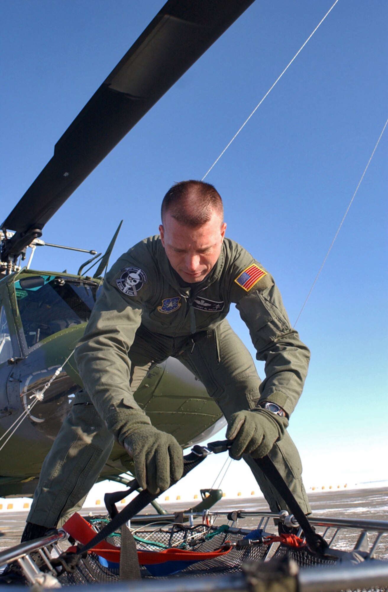 MALMSTROM AIR FORCE BASE, Mont. -- Tech. Sgt. Al Davis, of the 341st Operations Group, assembles a litter that can be used with a hoist mounted inside a UH-1N Huey.  (U.S. Air Force photo by Senior Airman John Parie)