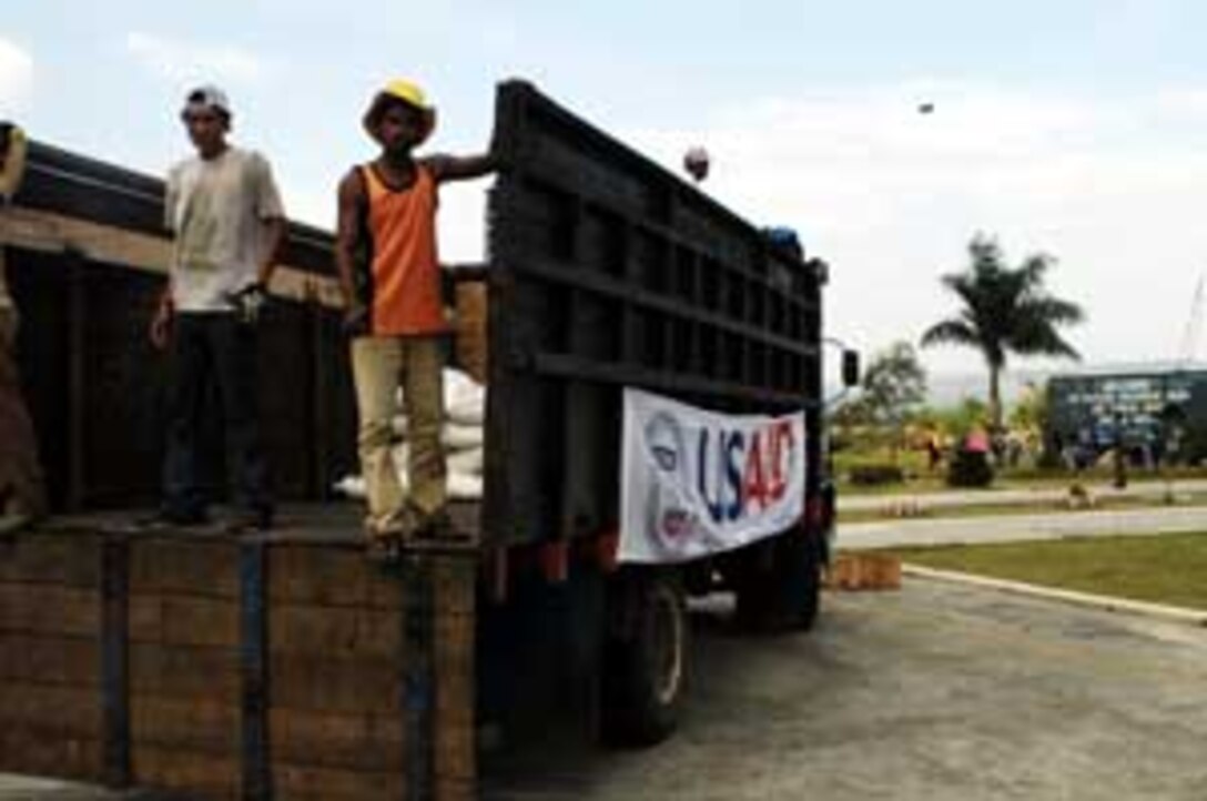 Indonesian volunteers ride a truck being used to transport US AID humanitarian aid at the airport here. Marines from the 15th Marine Expeditionary Unit (Special Operations Capable) and 3rd Marine Division have been assisting relief efforts since shortly after the disaster.