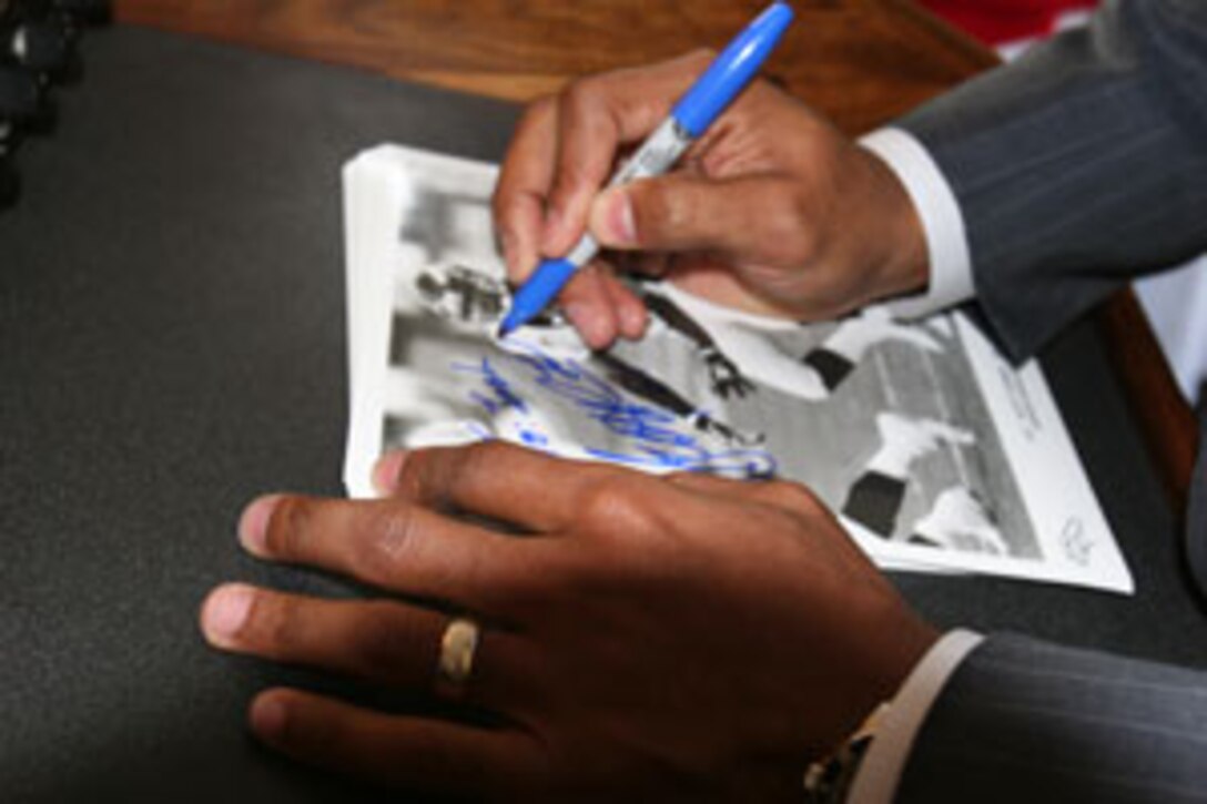 Denver Broncos? corner back Scott Turner signs a photo for a Marine at MCB Camp Lejeune, Jan. 7. Turner and a group of Congressional Delegates visited with service members and their families in one of a number of visits to bases to offer encouragement, with the underlying theme of determining the needs of the members and their families.