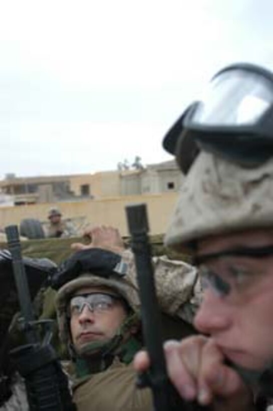 AR, RAMADI, Iraq (March 8, 2005) - Lieutenant j.g. Mike A. Quaresimo, 32, of Poughkeepsie, N.Y., and the information officer for Information Operations, Headquarters and Service Company, 1st Battalion, 5th Marines, 1st Marine Division, looks up at the building he's about to enter while riding in the back of a high-back humvee. Lance Cpl. Jordan F. Sherwood, 22, of Roanoke, Va., and a combat cameraman with 1st Marine Division, looks straight while thinking about the mission that awaits him. Marines with Company A, 1st Battalion, 5th Marines joined Company G, 2nd Battalion, 5th Marines in a raid on the hospital in search of weapons caches, insurgents and crimes against humanity. First Battalion, 5th Marines' Human Exploitation Team, Information Operations, the 4th and 5th Civil Affairs Groups and more than 20 Iraqi Security Force Commandos also participated in the mission, which lasted more than four hours. (Official United States Marine Corps photo by Cpl. Tom Sloan)