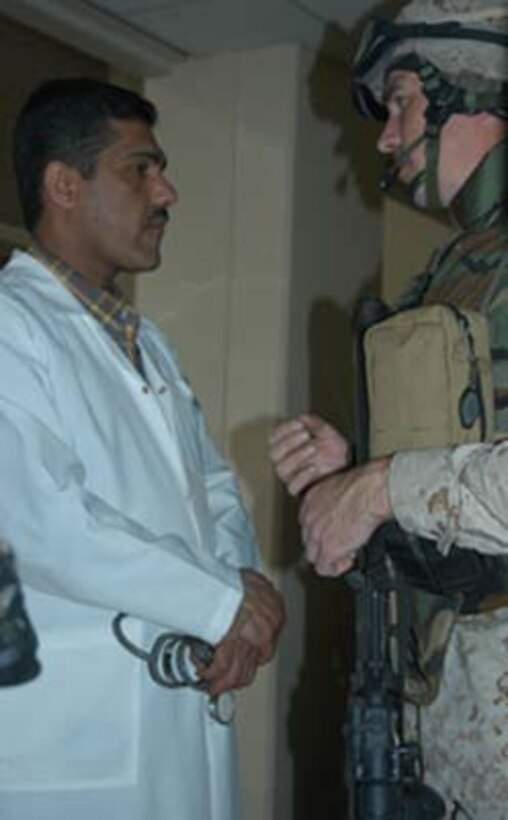 AR, RAMADI, Iraq (March 8, 2005) - Major Benjamin B. Busch, team leader, 5th Civil Affairs Group, 1st Battalion, 5th Marines, explains to a doctor at the Ar Ramadi General Hospital why his hospital is been searched. Marines with Company A, 1st Battalion, 5th Marines joined Company G, 2nd Battalion, 5th Marines in a raid on the hospital in search of weapons caches, insurgents and crimes against humanity. First Battalion, 5th Marines' Human Exploitation Team, Information Operations, the 4th and 5th Civil Affairs Groups and more than 20 Iraqi Security Force Commandos also participated in the mission, which lasted more than four hours.  (Official United States Marine Corps photo by Cpl. Tom Sloan)