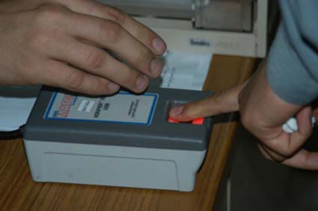 AR, RAMADI, Iraq (March 8, 2005) - Inside the Ar Ramadi General Hospital here, an Iraqi man has his fingerprint recorded while being entered into a database Marines use to locate insurgents. His name, photo and other personal information will also be entered. A system called the Biometric Automative Tools (BAT) enables Marines to upload and keep track of such information. Marines with Company A, 1st Battalion, 5th Marines joined Company G, 2nd Battalion, 5th Marines in a raid on the hospital in search of weapons caches, insurgents and crimes against humanity. First Battalion, 5th Marines' Human Exploitation Team, Information Operations, the 4th and 5th Civil Affairs Groups and more than 20 Iraqi Security Force Commandos also participated in the mission, which lasted more than four hours.  (Official United States Marine Corps photo by Cpl. Tom Sloan)