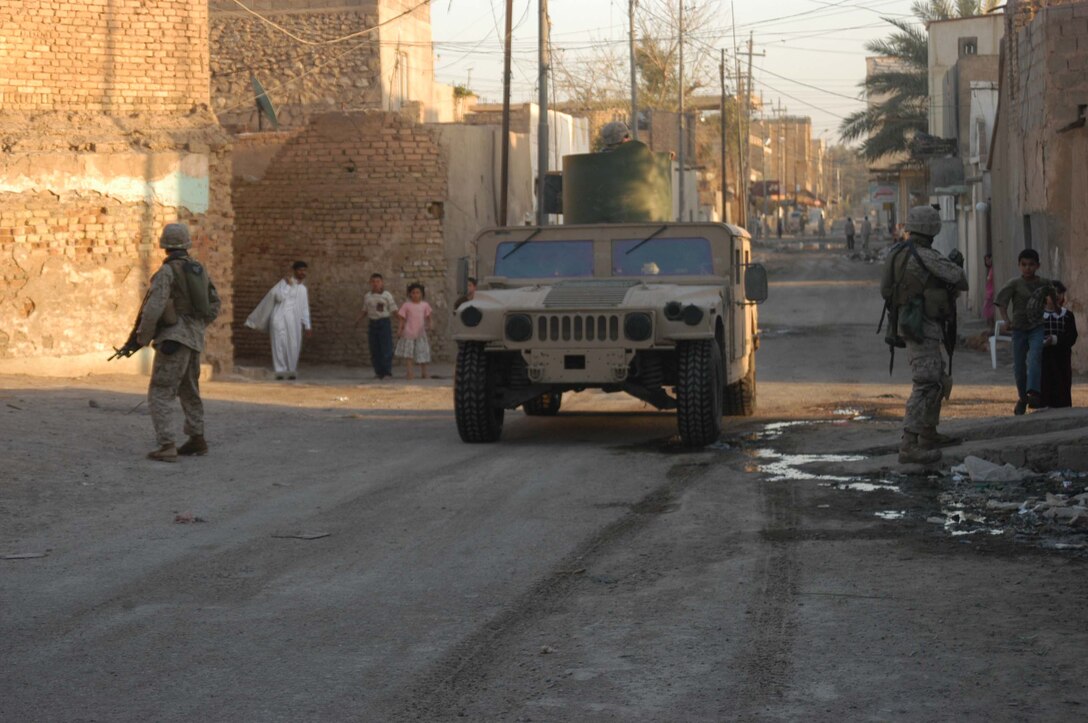 AR RAMADI, Iraq (April 8, 2005) - An up-armored Humvee travels down a road near the city's marketplace. Two Marines with 1st Squad, 4th Platoon, Company A, 1st Battalion, 5th Marine Regiment, walk alongside the vehicle while patrolling the area.  Marines with 4th Platoon, Company A, 1st Battalion, 5th Marines, patrolled the marketplace in an effort to familiarize themselves with their area of operations and determine how the local Iraqis feel about their presence in the area. The Marines also handed out positive and anti-insurgent propaganda to the Iraqis and searched for insurgents and things out of the ordinary during the two-hour operation. Photo by Cpl. Tom Sloan