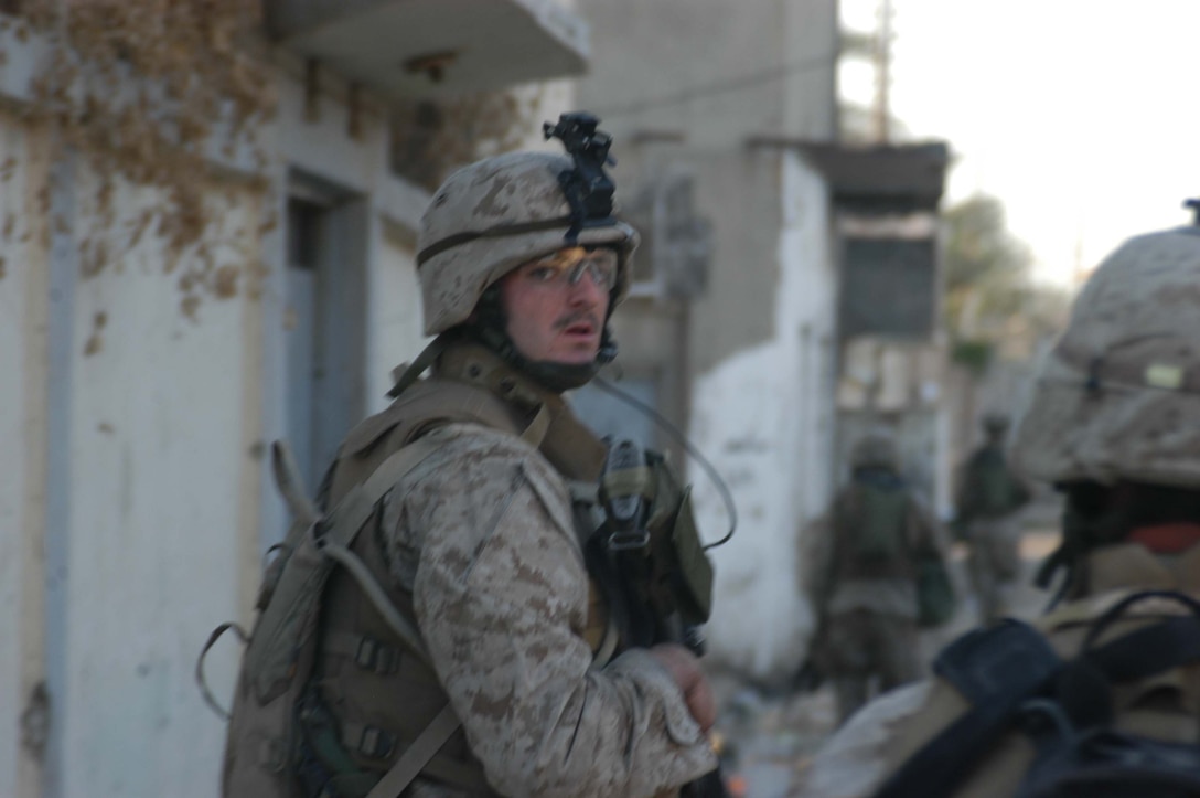 AR RAMADI, Iraq (April 8, 2005) - Lance Cpl. John D. Badon, team leader, 1st Squad, 4th Platoon, Company A, 1st Battalion, 5th Marine Regiment, looks back over his shoulder to see if his Marines are properly dispersed during a patrol of the marketplace here. The 22-year-old from Lufkin, Texas and other warriors with 4th Platoon, Company A, 1st Battalion, 5th Marines, patrolled the marketplace in an effort to familiarize themselves with their area of operations and determine how the local Iraqis feel about their presence in the area. The Marines also handed out positive and anti-insurgent propaganda to the Iraqis and searched for insurgents and things out of the ordinary during the two-hour operation. Photo by Cpl. Tom Sloan