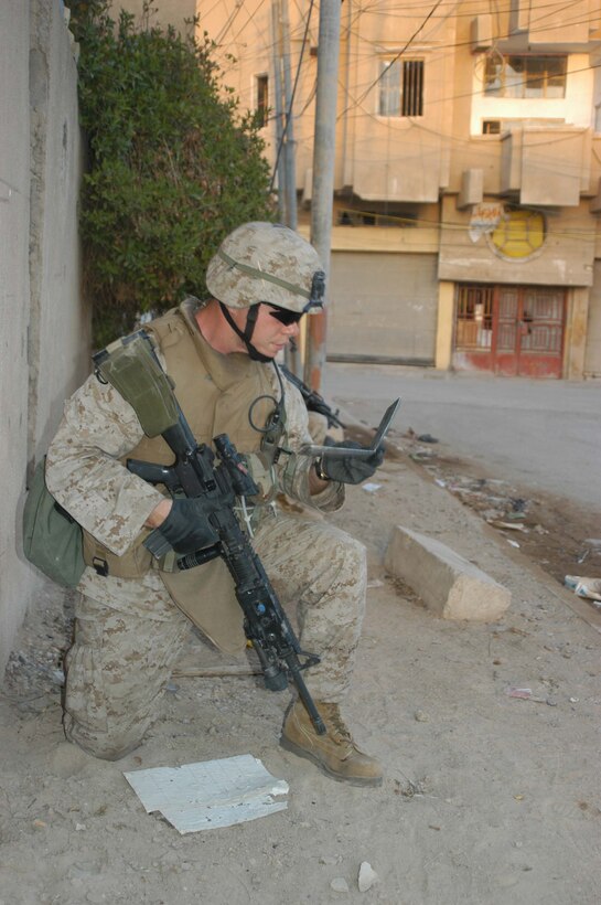 AR RAMADI, Iraq (April 8, 2005) - Sergeant Brian S. Foster, squad leader, 1st Squad, 4th Platoon, Company A, 1st Battalion, 5th Marine Regiment, takes a knee and looks at his map while patrolling the city's marketplace. The 27-year-old from Virginia Beach, Va., and other warriors with 4th Platoon, Company A, 1st Battalion, 5th Marines, patrolled the marketplace in an effort to familiarize themselves with their area of operations and determine how the local Iraqis feel about their presence in the area. The Marines also handed out positive and anti-insurgent propaganda to the Iraqis and searched for insurgents and things out of the ordinary during the two-hour operation. Photo by Cpl. Tom Sloan