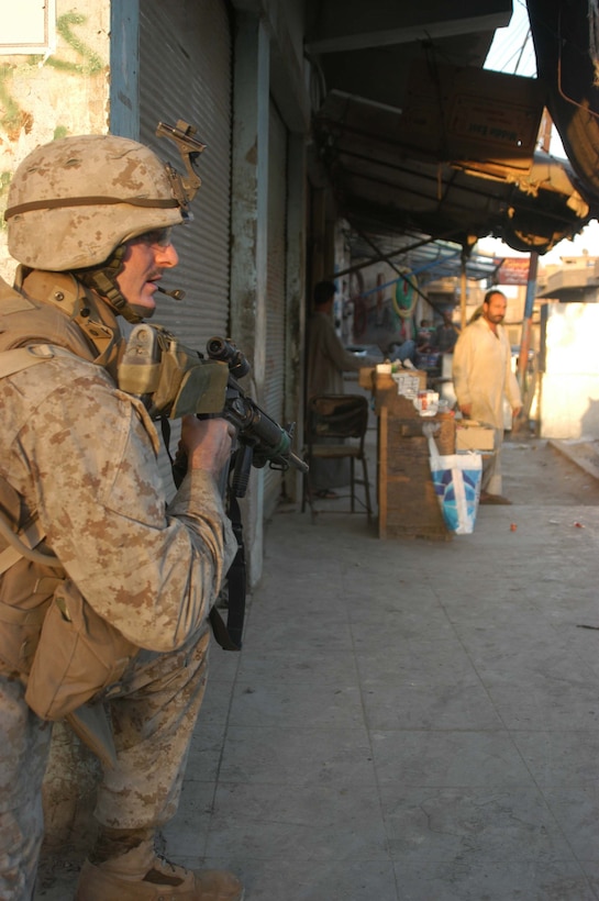 AR RAMADI, Iraq (April 8, 2005) - Lance Cpl. John D. Badon, team leader, 1st Squad, 4th Platoon, Company A, 1st Battalion, 5th Marine Regiment, takes a knee and provides security during a patrol of the marketplace here. The 22-year-old from Lufkin, Texas and other warriors with 4th Platoon, Company A, 1st Battalion, 5th Marines, patrolled the marketplace in an effort to familiarize themselves with their area of operations and determine how the local Iraqis feel about their presence in the area. The Marines also handed out positive and anti-insurgent propaganda to the Iraqis and searched for insurgents and things out of the ordinary during the two-hour operation. Photo by Cpl. Tom Sloan