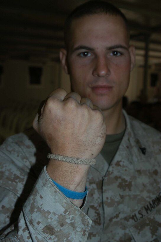 CAMP RAMADI Ar Ramadi, Iraq (June 7, 2005) - Corporal Donald W. Ball, a team leader and rifleman with 3rd Squad, Weapons Platoon, Company B, 1st Battalion, 5th Marine Regiment, shows off his war fighters bracelet during a memorial ceremony here for his late friend, Cpl. Jeff B. Starr. Starr was killed May 30, Memorial Day, by small arms fire while conducting operations against enemy forces in this city. Ball, a 22-year-old from Salt Lake City, who served alongside Starr during three deployments in support of Operation Iraqi Freedom, gave a eulogy during the ceremony. Photo by: Cpl. Tom Sloan