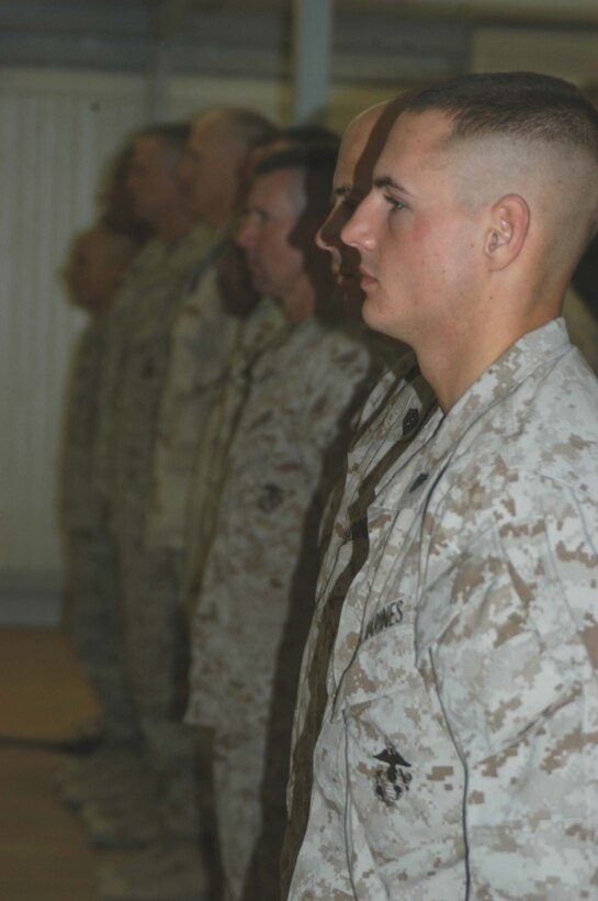 CAMP RAMADI Ar Ramadi, Iraq (June 7, 2005) - Corporal Donald W. Ball, a team leader and rifleman with 3rd Squad, Weapons Platoon, Company B, 1st Battalion, 5th Marine Regiment, stands at the position of attention with fellow Marines while Taps plays during a memorial ceremony here for Cpl. Jeff B. Starr. Starr was killed May 30, Memorial Day, by small arms fire while conducting operations against enemy forces in this city. Starr was a 22-year-old native of Snohomish, Wash. Ball, a 22-year-old from Salt Lake City, who served alongside Starr during three deployments in support of Operation Iraqi Freedom, gave a eulogy during the ceremony. Photo by: Cpl. Tom Sloan