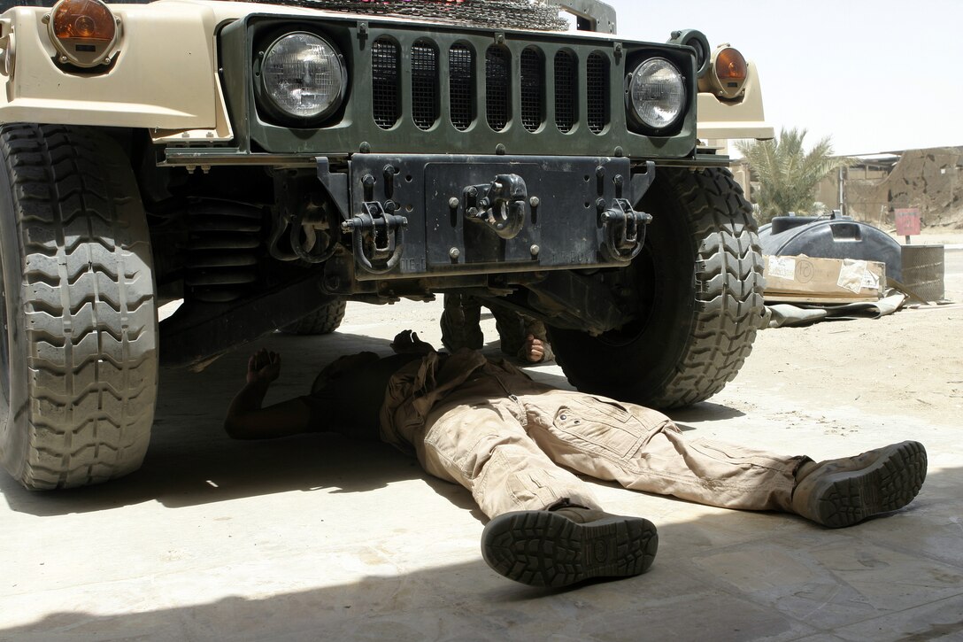 CAMP BAHARIA, Iraq - A mechanic with 1st Battalion, 6th Marine Regiment's motor transport section prepares to work underneath a vehicle here June 8.  The battalion's Motor 'T' Marines service several military trucks' engines, transmissions and electric systems, along with freighting fuel and water to locations throughout the camp and Fallujah.