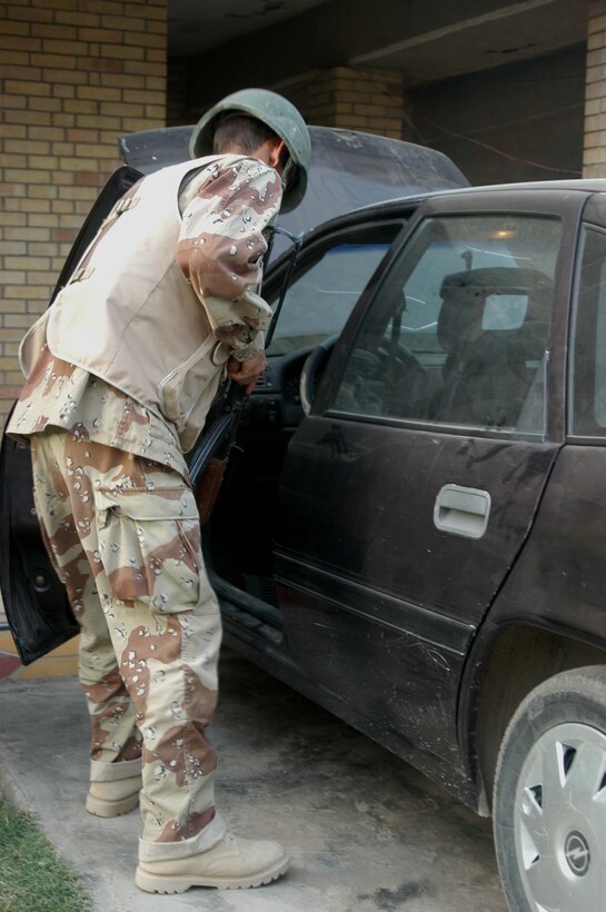 AR RAMADI, Iraq (Aug. 8, 2005) -A member of the Iraqi Security Forces searches a car in an Iraqi man's driveway during a mission in the city here Aug. 8. Many of the Al Anbar capital's locals respond well to having ISF patrol through their neighborhoods conducting security and stabilization operations. Marines with the Combined Action Platoon(CAP), Company B, 1st Battalion, 5th Marine Regiment, support Operation Iraqi Freedom by training new members of the ISF and employing them on Ramadi's urban battlefield to help secure the city from terrorism. The Marines are letting the ISF carry more of the operational workload because their tactics are improving. Iraqi Security Forces are even leading their own foot patrols. Photo by: Cpl. Tom Sloan
