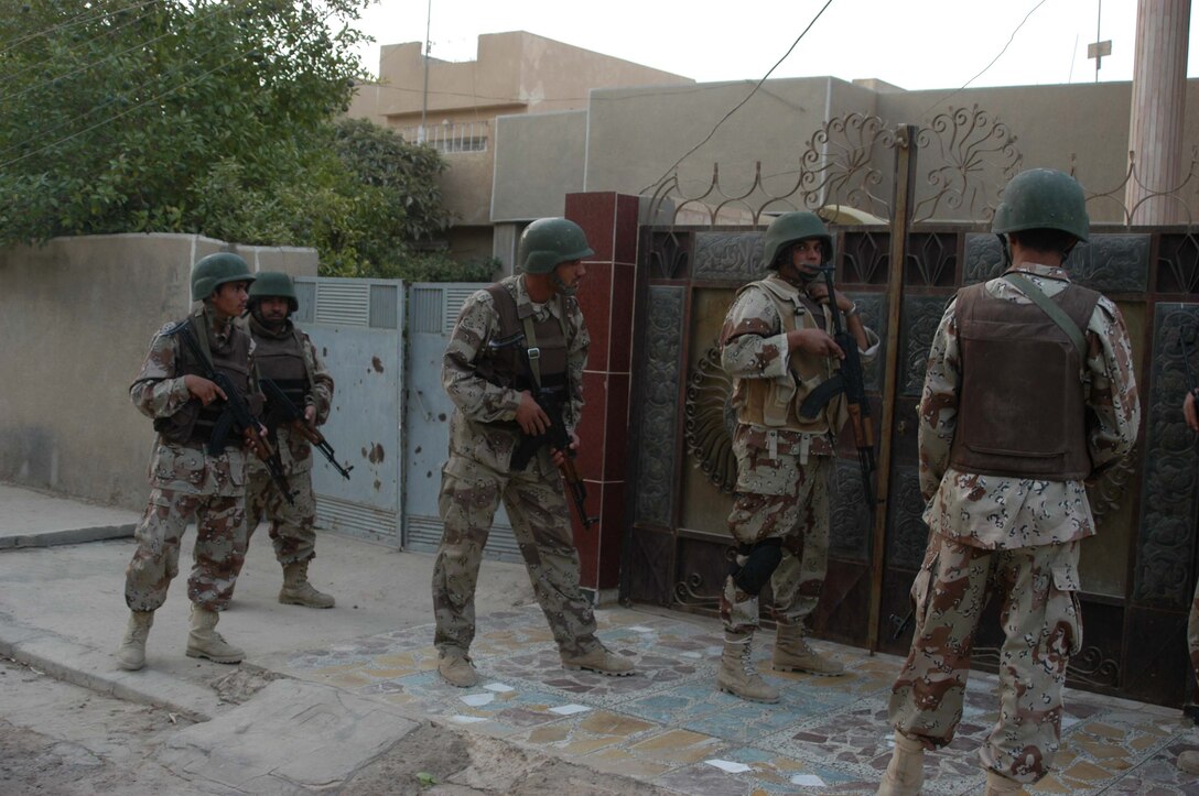 AR RAMADI, Iraq (Aug. 8, 2005) -A squad of the Iraqi Security Forces prepare to enter a residence during a mission in the city here Aug. 8. Many of the Al Anbar capital's locals respond well to having ISF patrol through their neighborhoods conducting security and stabilization operations. Marines with the Combined Action Platoon(CAP), Company B, 1st Battalion, 5th Marine Regiment, support Operation Iraqi Freedom by training new members of the ISF and employing them on Ramadi's urban battlefield to help secure the city from terrorism. The Marines are letting the ISF carry more of the operational workload because their tactics are improving. Iraqi Security Forces are even leading their own foot patrols. Photo by: Cpl. Tom Sloan