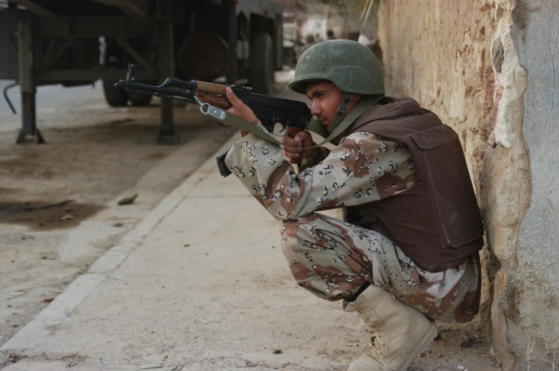 AR RAMADI, Iraq (Aug. 8, 2005) -A member of the Iraqi Security Forces gets provides security for his comrades during a mission in the city here Aug. 8. Marines with the Combined Action Platoon(CAP), Company B, 1st Battalion, 5th Marine Regiment, support Operation Iraqi Freedom by training new members of the ISF and employing them on Ramadi's urban battlefield to help secure the city from terrorism. The Marines are letting the ISF carry more of the operational workload because their tactics are improving. Iraqi Security Forces are even leading their own foot patrols. Photo by: Cpl. Tom Sloan
