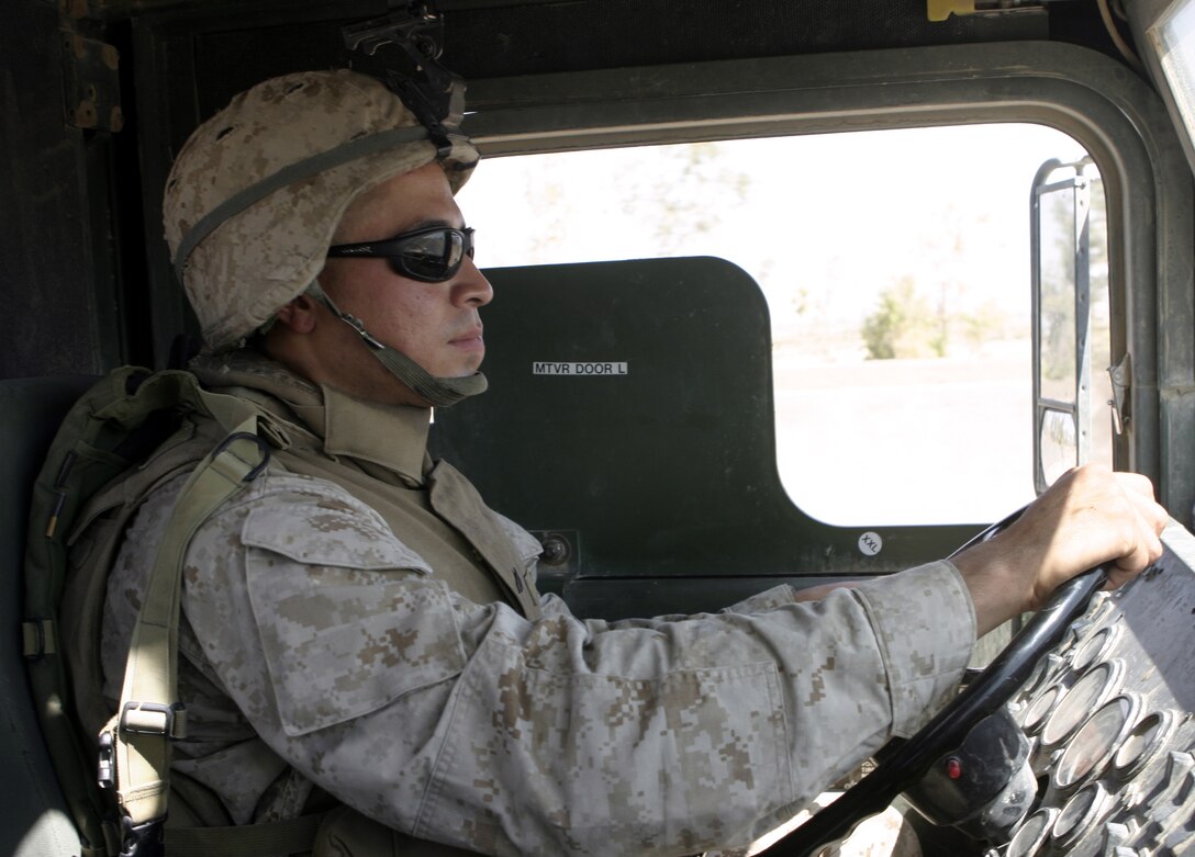 CAMP BAHARIA, Iraq - Corporal. Jesus Valles, a vehicle operator with 2nd Platoon, Truck Company, Headquarters Battalion, 3rd Marine Division, drives his seven-ton truck while on a logistics convoy here.  The 25-year-old Pecos, Texas native and his fellow vehicle mechanics and operators, originally from Okinawa, have been working alongside 1st Battalion, 6th Marine Regiment personnel in and around Fallujah since mid-March, accomplishing tasks such as servicing vehicles, conducting supply and logistics convoys, and transporting the infantrymen around the city.