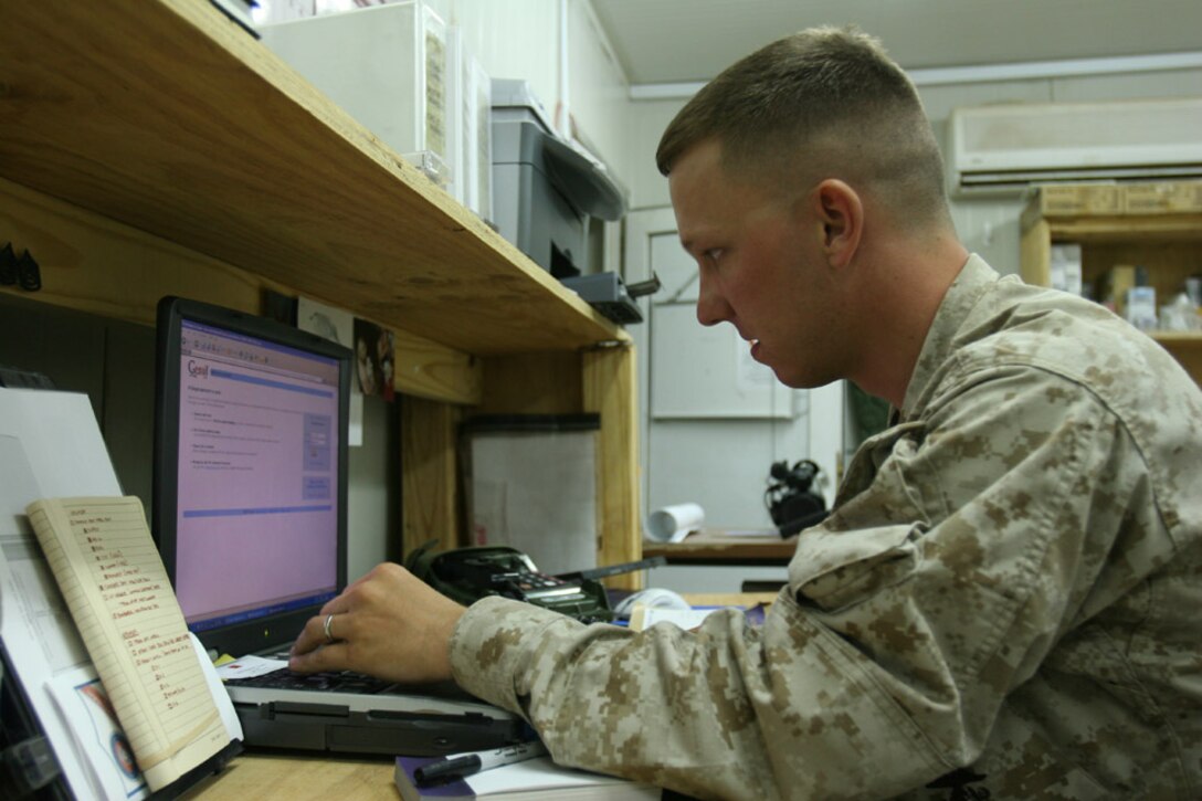 050928-M-2607O-002 CAMP FALLUJAH, Iraq -- Lance Cpl. Matthew J. Hutchison, Combat Cameraman with 2d Battalion, 2d Marine Regiment, accesses his email account to watch the video of first child, Benjamin, being born with assistance from the hospital back in the United States.  Hutchison coordinated with the hospital when he was on leave a few months prior and the hospital was more than willing to assist him any way possible.