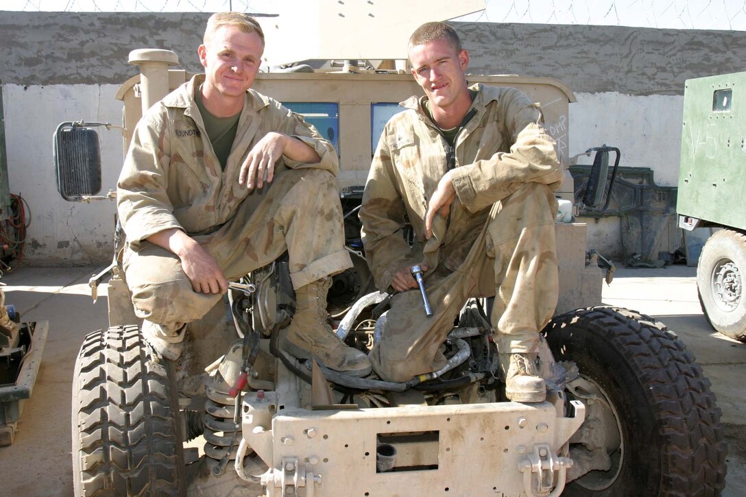 HADITHA DAM, Iraq (Oct. 22, 2005)  - (left to right) Claremore, Okla. native Cpl. Timothy R. Roundtree and Orland, Calif. native Cpl. Joshua E. Thompson, both mechanics for 3rd Battalion, 1st Marine Regiment, have worked side by side since joining the Marines December 2002. Now on their second deployment together, these two Marines continue to work as a fluid team to keep their unit's vehicles driving on the road. (Official Marine Corps photo by Cpl. Adam C. Schnell)