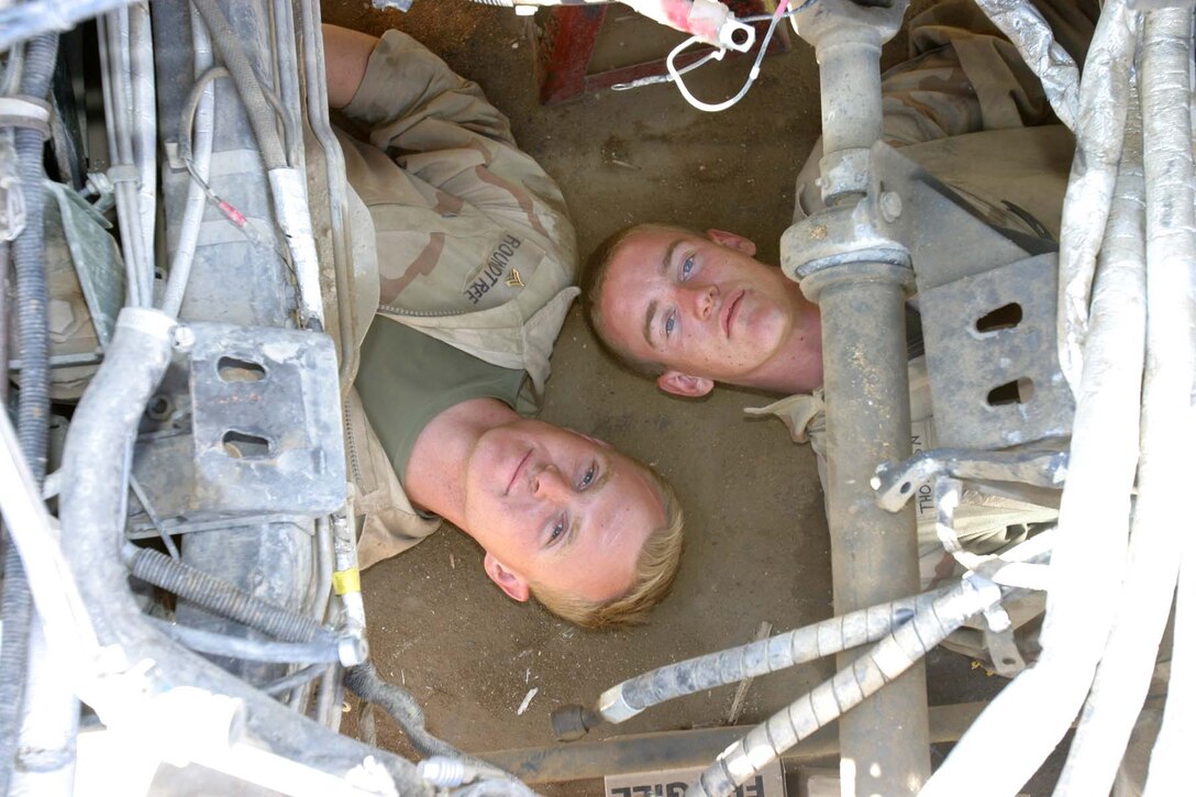 HADITHA DAM, Iraq (Oct. 22, 2005)  - (left to right) Claremore, Okla. native Cpl. Timothy R. Roundtree and Orland, Calif. native Cpl. Joshua E. Thompson, both mechanics for 3rd Battalion, 1st Marine Regiment, have worked side by side since joining the Marines December 2002. Now on their second deployment together, these two Marines continue to work as a fluid team to keep their unit's vehicles driving on the road. (Official Marine Corps photo by Cpl. Adam C. Schnell)