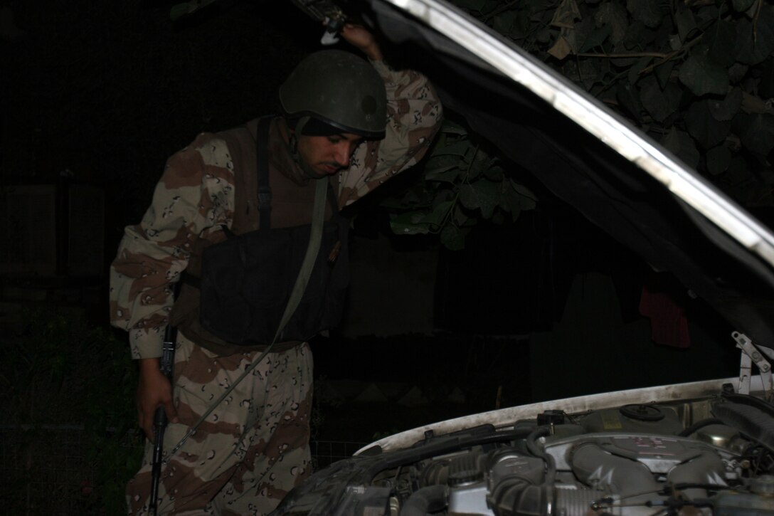 AR RAMADI, Iraq (December 8, 2005) - An Iraqi soldier searches a car for abnormalities during Operation Skinner Dec. 8. Photo by Cpl. Shane Suzuki