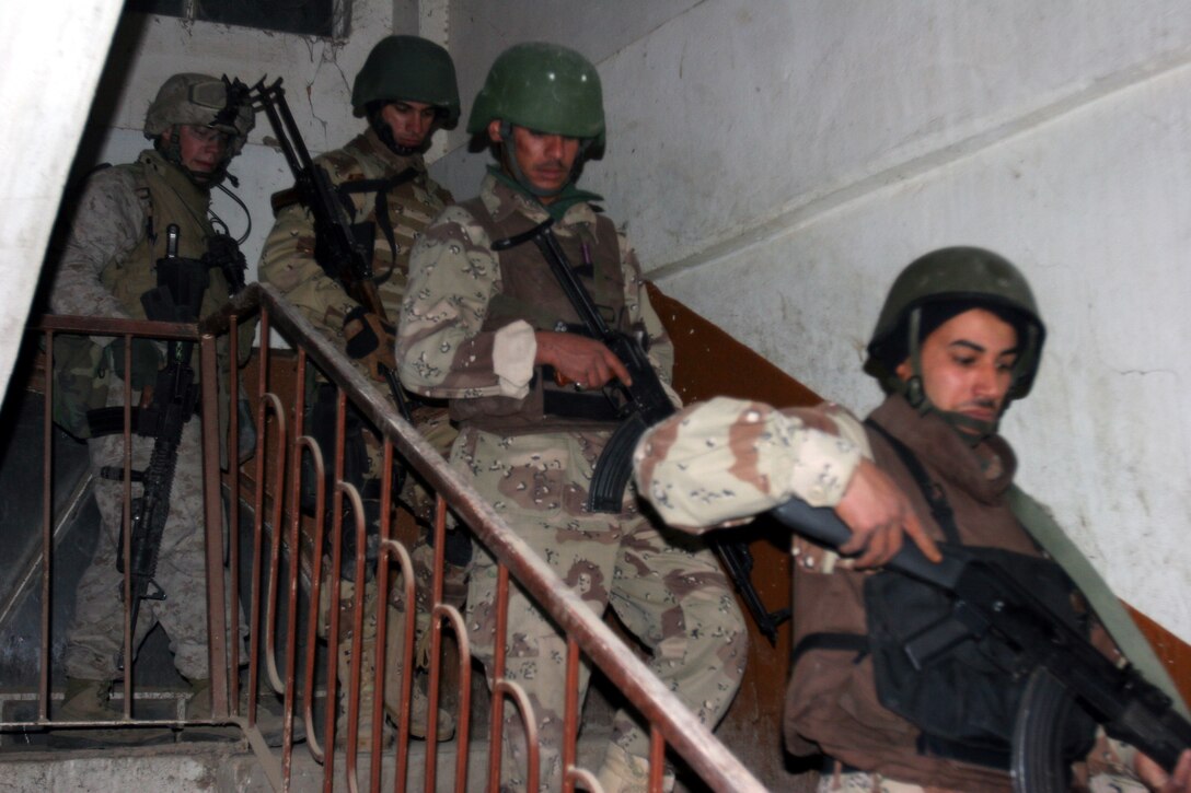AR RAMADI, Iraq (December 8, 2005) - A Marine with Company I, 3rd Battalion, 7th Marine Regiment and three Iraqi soldiers search a building for illegal weapons caches during Operation Skinner Dec. 8. Photo by Cpl. Shane Suzuki