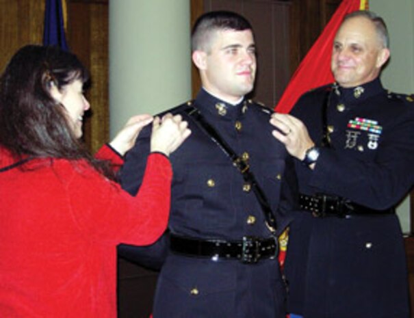 Retired Maj. Greg Butler and his wife Nancy pin the rank of 2nd Lt. on their son Justin at his commissioning ceremony at the Monroe County courthouse Jan. 8. Lieutenant Butler becomes the third generation of the butler family to serve in the Marine Corps.