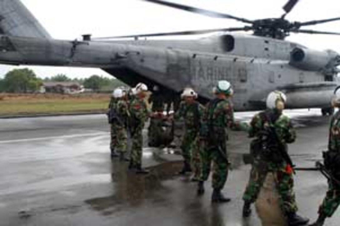 A group of Indonesian soldiers unload their gear at an airfield here after being transported by a 15th Marine Expeditionary Unit (Special Operations Capable) CH-53E Super Stallion helicopter from Banda Aceh.