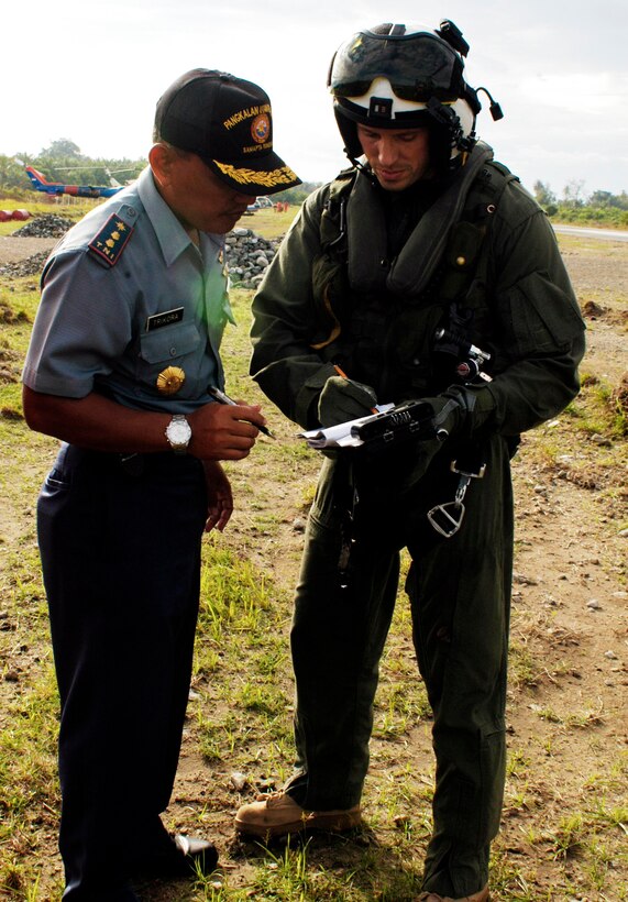 BLANG PIDIE, Indonesia (Jan. 9, 2005) -- Maj. Todd Oneto, executive officer of Marine Medium Helicopter Squadron 165 (REIN) and CH-46E Sea Knight pilot, speaks to Trikora, an Indonesia government representative about aid being delivered to the area. The 15th Marine Expeditionary Unit (Special Operations Capable) has been providing desperately needed humanitarian aid to cities and villages along more than 150 miles of Sumatra's western coastline.  (Photo by Gunnery Sgt. Robert Knoll)