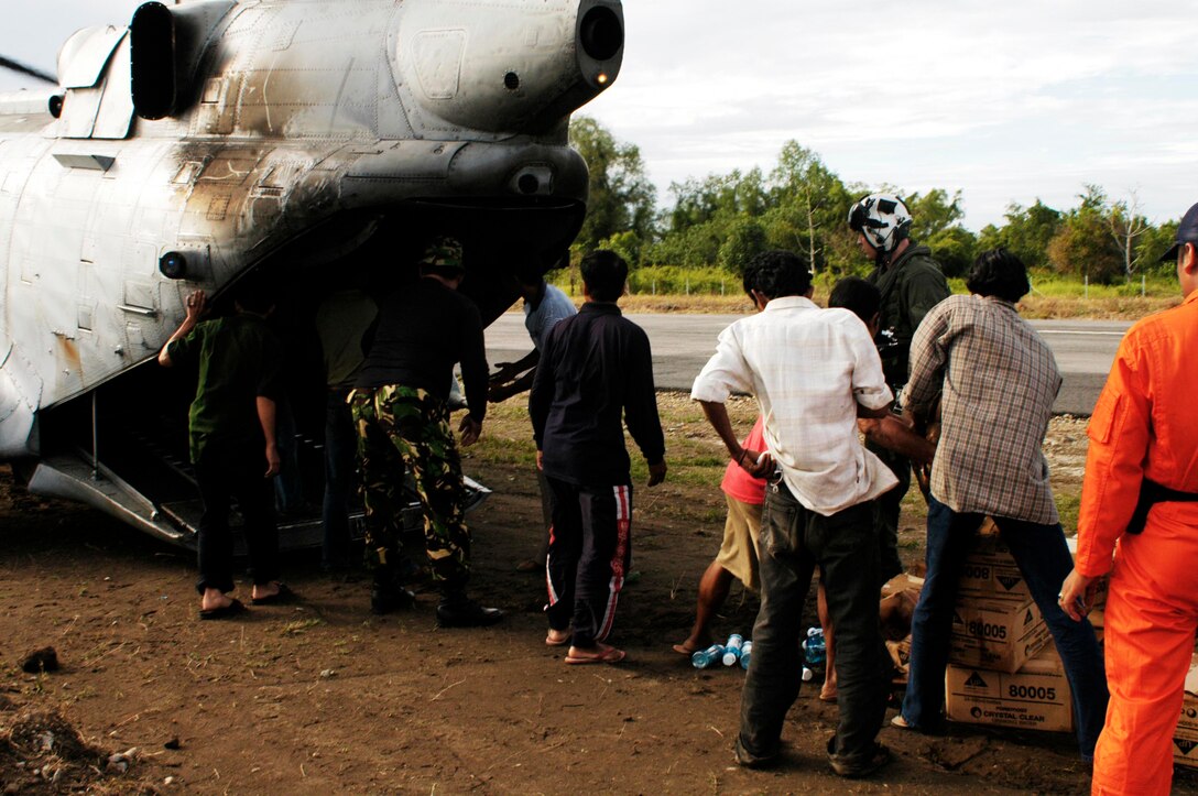 BLANG PIDIE, Indonesia (Jan. 9, 2005) -- Crew chiefs and pilots on a CH-46E Sea Knight helicopter deliver bottled water to residents of this area. The 15th Marine Expeditionary Unit (Special Operations Capable) has been providing desperately needed humanitarian aid to cities and villages along more than 150 miles of Sumatra's western coastline.  (Photo by Gunnery Sgt. Robert Knoll)