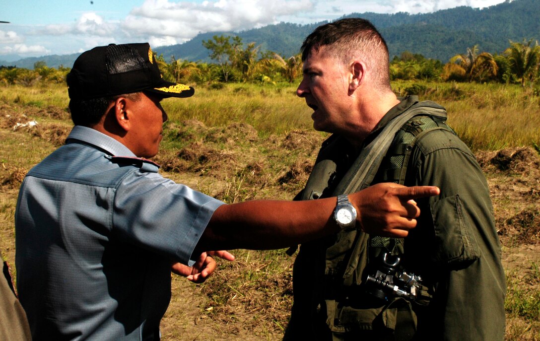 BLANG PIDIE, Indonesia (Jan. 9, 2005) -- Maj. Ron Carson, 38, a CH-53E pilot with Marine Medium Helicopter Squadron 165 (REIN) speaks to Trikoria, an Indonesian government representative about a fuel delivery here. The 15th Marine Expeditionary Unit has been providing desperately needed humanitarian aid to cities and villages along more than 150 miles of Sumatra's western coastline.  (Photo by Gunnery Sgt. Robert Knoll)