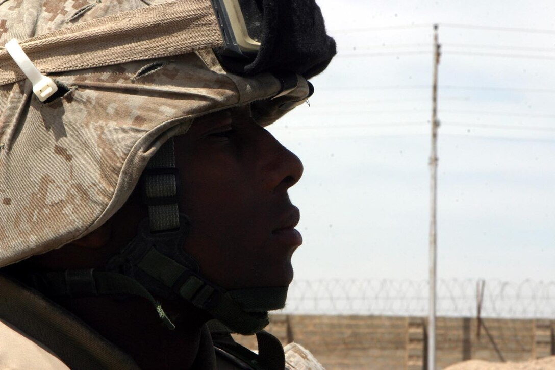 CAMP FALLUJAH, IRAQ -- Sitting in the back of the vehicle, Lance Cpl. Juan T. O'Neal looks around the area as they had just entered back into friendly lines after a quiet day on the road..  O'Neal is one of the Marines who works on the Personal Security Detachment when the XO goes out.  Official U.S. Marine Corps photo by Lance Cpl. Athanasios L. Genos