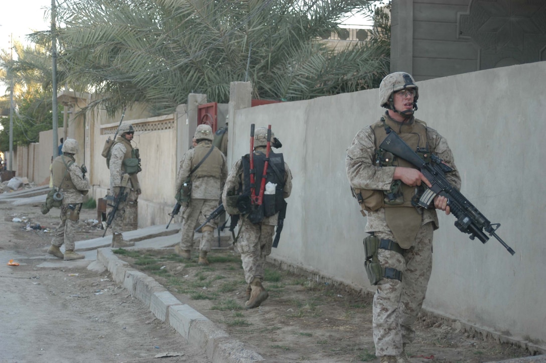 AR RAMADI, Iraq (May 9, 2005) - Corporal Tyler S. Trovillion, a grenadier and team leader with 3rd Squad, 2nd Platoon, Company A, 1st Battalion, 5th Marine Regiment, turns around to see if his Marines are trailing close behind during a mission in the city here. The 23-year-old from Richardson, Texas and his fellow warriors with 3rd Squad, 2nd Platoon, Company A, 1st Battalion, 5th Marines, conducted a presence patrol through a neighborhood and discovered a vehicle that was mount with Texas Truck license plates. Marines with 3rd Squad are the self-proclaimed masters of finding hidden, insurgent material. Photo by Cpl. Tom Sloan