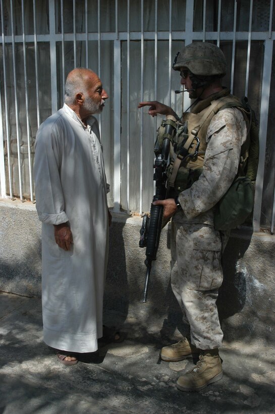 AR RAMADI, Iraq (June 2, 2005) - Lance Cpl. Tony Leal, a rifleman and team leader with 3rd Squad, 4th Platoon, Company A, 1st Battalion, 5th Marine Regiment, talks to an Iraqi man during a mission in the city here.  The 24-year-old from Staford, Texas, is on his second deployment to Iraq supporting Operation Iraqi Freedom. Leal is a 2003 graduate of Sam Houston State University, Huntsville, Texas, and holds an Associates degree in criminal justice. Photo by: Cpl. Tom Sloan