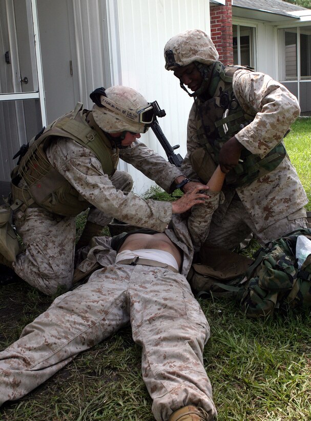TARAWA TERRACE I, N.C. - Cleveland native Lance Cpl. Jarrod T. Gray (left) and Nacogaodes, Texas native Seaman Ricky J. Peterson, C Company, 2d Combat Engineer Battalion, 2d Marine Division treat a simulated casualty during urban warfare training June 9, 2005.  (Official U.S. Marine Corps photo by Sgt. Jerad W. Alexander)