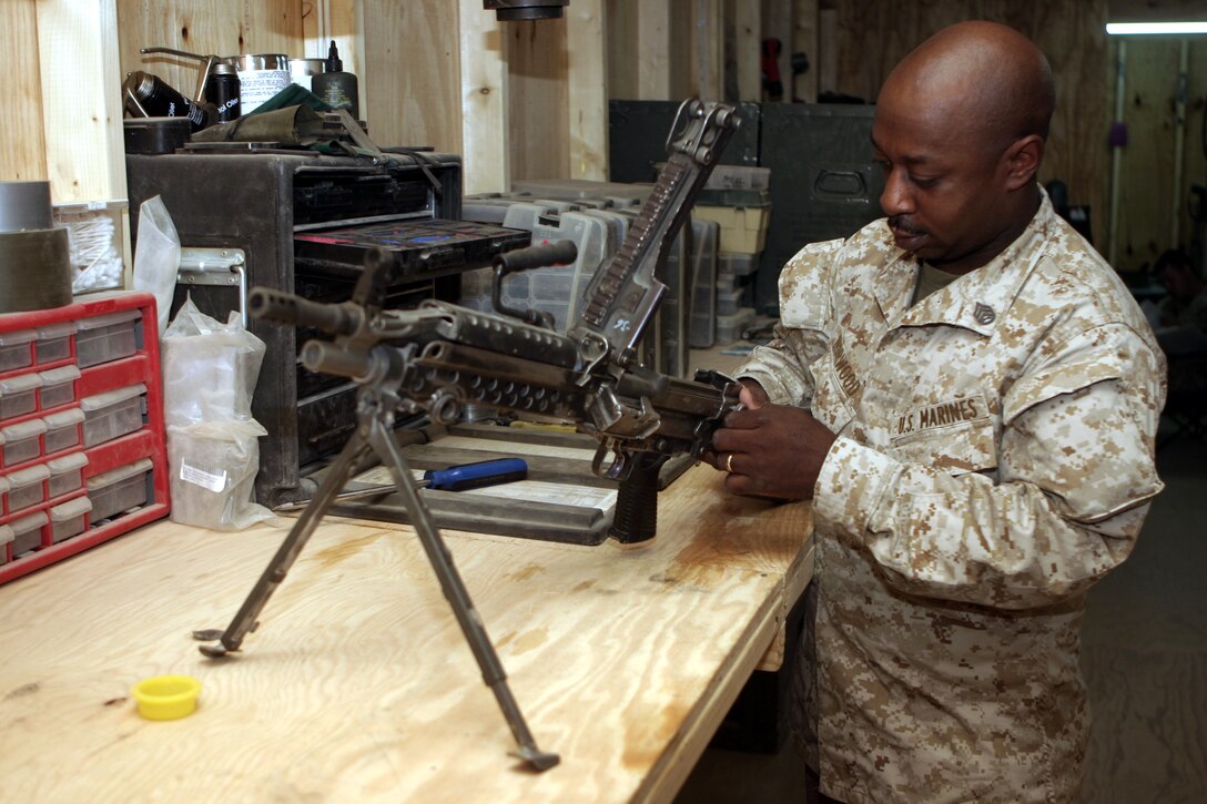 CAMP BAHARIA, Iraq - Staff Sgt. Kevin Norwood, 1st Battalion, 6th Marine Regiment's armory chief, inspects an M249 Squad Automatic Weapon here Aug. 9.  Every week, the battalion's small arms and optics technicians troubleshoot, inspect and repair more than 100 rifles, machineguns and night-vision units that infantrymen use while they patrol the streets of Fallujah.