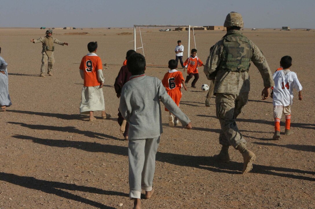 Marines from 2d Light Armored Reconnaissance Battalion and 5th Civil Affairs Group and soldiers from Camp Korean Village put nets on abandoned soccer goals and have a friendly game with the local children. The Marines and soldiers handed out toys, soccer balls and hygiene items to the kids after the game (Photo by LCpl. Zachary W. Lester)