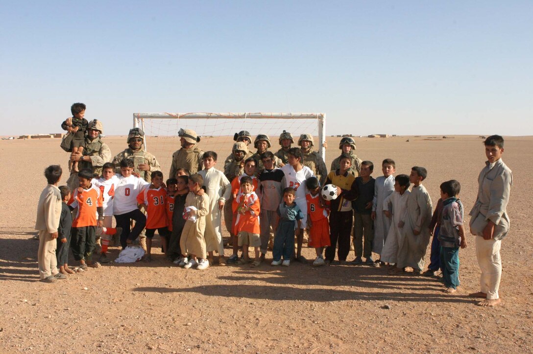 Marines from 2d Light Armored Reconnaissance Battalion and 5th Civil Affairs Group and soldiers from Camp Korean Village put nets on abandoned soccer goals and have a friendly game with the local children. The Marines and soldiers handed out toys, soccer balls and hygiene items to the kids after the game (Photo by LCpl. Zachary W. Lester)